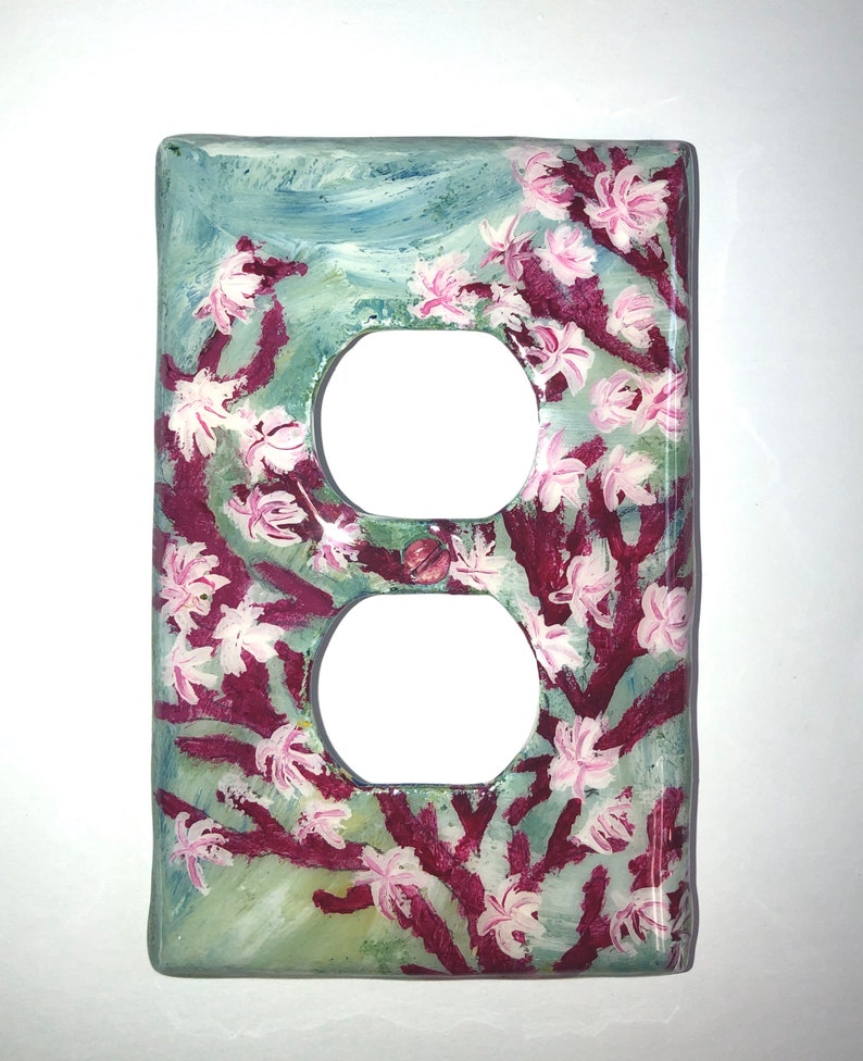 Ocean theme hand-painted on a vertical outlet wall plate cover with pink blooming coral and light grey color fish set against a blended light green color background. Artwork is protected with a resin glaze to ensure durability and give a glass like finish. Signed by Artist TDavis. Made to order with a variety of wall plate sizes available. Allow 10-14 days studio time