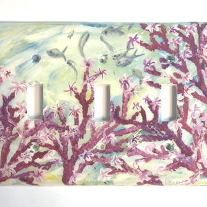 Ocean theme hand-painted on a three toggle light switch plate cover with pink blooming coral and light grey color fish set against a blended light green color background. Artwork is protected with a resin glaze to ensure durability and give a glass like finish. Signed by Artist TDavis. Made to order with a variety of wall plate sizes available. Allow 10-14 days studio time