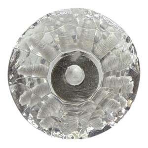 Può includere: Pomello per armadio in vetro trasparente sfaccettato con base in metallo color argento. Il pomello ha una forma rotonda con una superficie strutturata, creando un effetto scintillante. Ideale per aggiungere un tocco di eleganza ai mobili.