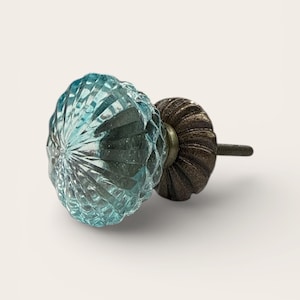 Puede incluir: Pomo decorativo para armario con cabeza de cristal facetado azul claro y base de metal bronce oscuro. El pomo tiene un diseño acanalado y un tornillo roscado. Ideal para añadir un toque de elegancia a los muebles.
