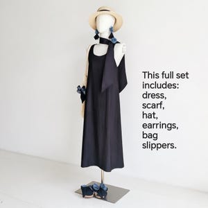 May include: A complete fashion set on a mannequin, including a black dress, scarf, hat, earrings, bag, and slippers. The hat is beige, and the earrings and slippers have blue accents. The text on the right says "This full set includes: dress, scarf, hat, earrings, bag slippers."