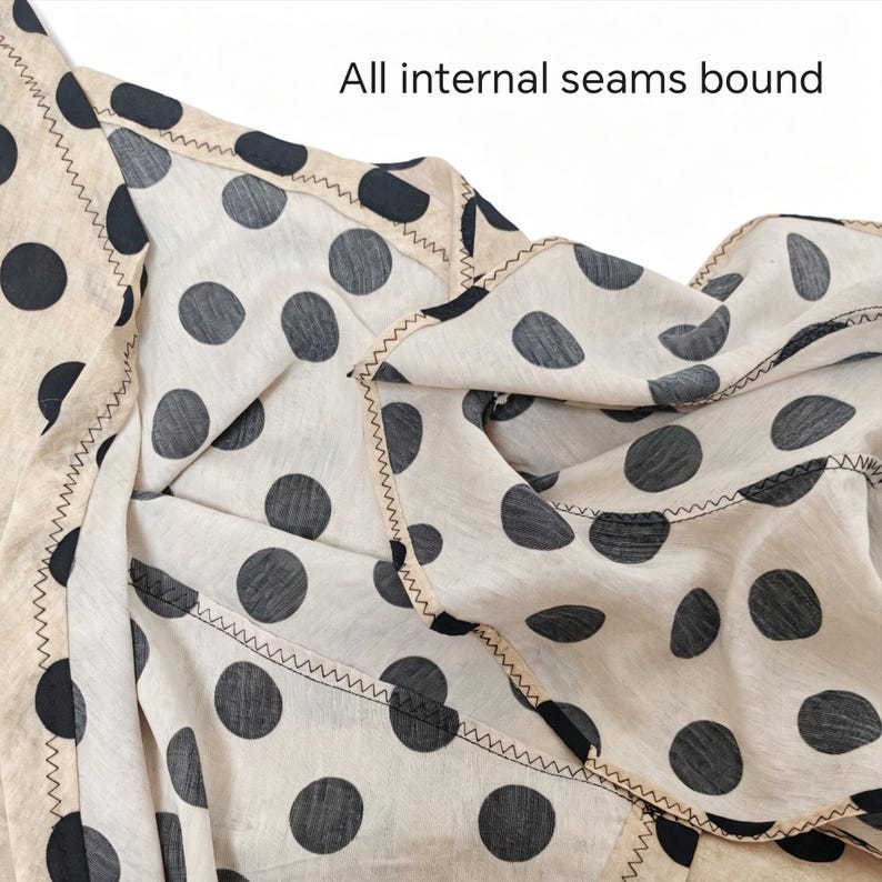 May include: A cream-colored fabric featuring a black polka dot pattern with all internal seams bound by a beige trim and finished with a dark zigzag stitch. The text "All internal seams bound" is clearly visible at the top of the image.