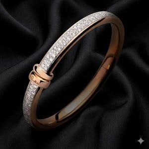 May include: Rose gold bangle bracelet with a row of sparkling white gemstones. The bracelet has a knot design at the clasp and is set against a black background. The bracelet is a piece of jewelry.