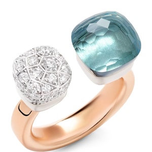 Op de afbeelding: Een roségouden ring met twee vierkante edelstenen. De ene is een cluster van kleine diamanten, de andere een grote, facetgeslepen, lichtblauwe edelsteen. De ring heeft een modern, open ontwerp.