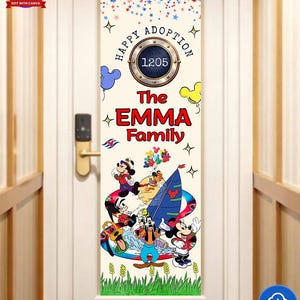 K&ouml;nnte beinhalten: T&uuml;rdekoration mit einem farbenfrohen Design mit Micky Maus und Freunden. Der Text lautet "Happy Adoption" und "The Emma Family". Das Design umfasst Ballons, Sterne und ein nautisches Emblem mit der Nummer 1205.