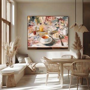 May include: An abstract painting of a table setting with a cup of tea, cake, and various beverages. The artwork features a colorful, impressionistic style with a gold frame. The painting is displayed above a dining table with woven chairs.