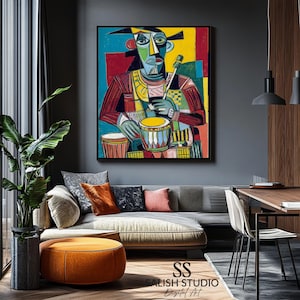 May include: Abstract artwork depicting a drummer, with a bold use of red, blue, yellow, and green. The painting is framed in black and displayed on a grey wall. The image includes the text "SALISH STUDIO Digital Art".