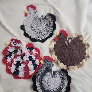 May include: Four handmade crochet potholders shaped like chickens. Two are grey and black with red combs, one is brown with a cream and green border and red comb, and one is a multi-colored pattern of red, white, and black with a red border.
