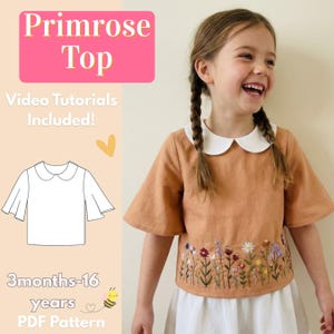 Könnte beinhalten: Ein Mädchen trägt ein beigefarbenes Primrose Top mit weißem Bubikragen und floraler Stickerei. Das Bild enthält den Text "Primrose Top", "Video Tutorials Included!" und "3 months-16 years PDF Pattern".