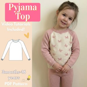 Puede incluir: Una niña pequeña con un conjunto de pijama rosa y crema. La parte superior presenta un estampado de mariposas en la parte delantera y mangas rosas. La imagen incluye el texto "Pyjama Top" y "Video Tutorials Included!"