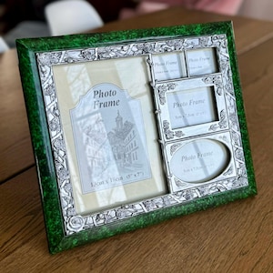 May include: A multi-photo frame with a green border and silver accents. The frame has a large central photo area, 5" x 7", and three smaller frames. The frame is decorated with floral patterns and the words "Photo Frame".