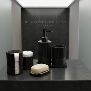 Puede incluir: Un conjunto de accesorios de baño negro mate, que incluye un dispensador de jabón, un jabonera, un soporte para bastoncillos de algodón y un recipiente para discos de algodón. El texto "RIB. ACCESSORIES COLLECTION" es visible.