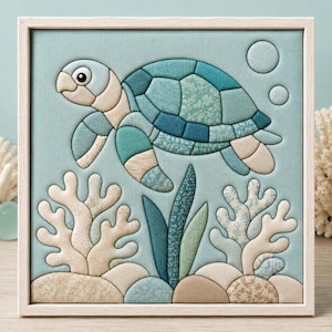 May include: A square framed fabric wall art piece featuring a sea turtle swimming above coral reefs and rocks. The turtle is composed of various shades of blue and teal patterned fabric patches. The background is a solid light blue fabric.