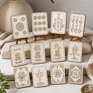 May include: A collection of wooden Mahjong tiles, each with unique symbols and designs, displayed on small wooden easels. The tiles feature various patterns, including circles, bamboo stalks, and Chinese characters, set against a light background.