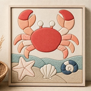 May include: A square framed wall art piece featuring a fabric-textured crab in shades of red and peach, positioned above a sandy beach scene with a fabric starfish, a white scallop shell, and a blue spiral seashell on a light beige background.