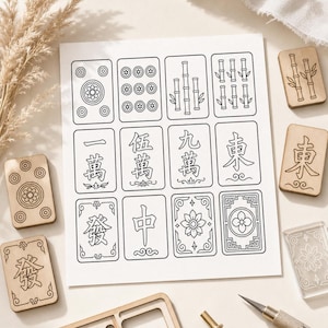 May include: A collection of Mahjong tiles and accessories. The image features a sheet of paper with black and white illustrations of Mahjong tiles, alongside wooden and clear acrylic tiles. A craft knife and other tools are also visible.