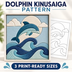 Op de afbeelding: Een vierkant ingelijst Kinusaiga-stofkunstwerk met een blauwe dolfijn die over donker- en lichtblauwe golven springt tegen een bleke zon en wolken, vergezeld van een zwart-wit lijntekening met de tekst DOLPHIN KINUSAIGA PATTERN.