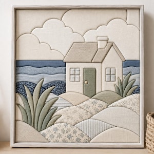 May include: A square fabric wall art piece featuring a layered textile collage of a coastal cottage. The scene includes a beige house with a green door, blue ocean waves, sandy dunes with floral patterns, and green foliage, all framed in light wood.