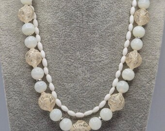 Collana vintage di perline in lucite reattive ai raggi UV, bianche, di dimensioni graduate.