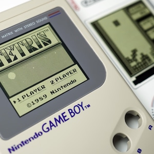 Original Nintendo Game Boy screen showing Tetris beside printed console details, creating nostalgic wall art for retro gaming collectors – juego clásico, klassisches Videospiel, nostalgische gamekunst.