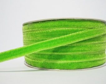 May include: A spool of bright green velvet ribbon. The ribbon is soft and has a subtle sheen.
