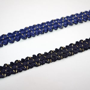May include: Two pieces of navy blue trim with gold thread woven through it. The trim has a scalloped edge.