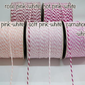 May include: A selection of pink and white baker's twine spools, with shades like rose, hot, peach, soft, and carnation pink. The image includes text indicating the colour combinations. Suitable for crafts and gift wrapping.