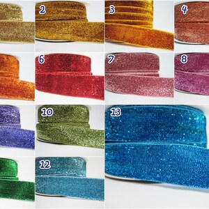 May include: Twelve spools of glitter ribbon in various colors, including gold, red, pink, blue, green, and purple. Each spool is labeled with a number from 1 to 13.