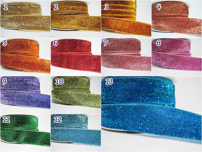May include: Twelve spools of glitter ribbon in various colors, including gold, red, pink, blue, green, and purple. Each spool is labeled with a number from 1 to 13.