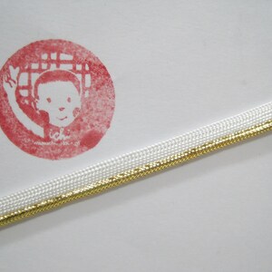 May include: White and gold trim with a red circle stamp featuring a cartoon child with the text "ichi" and a website address.
