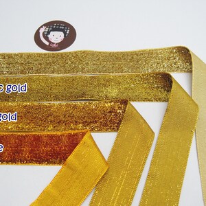 May include: Four different colors of ribbon, gold, classic gold, dark gold, and orange. The ribbon is shiny and has a metallic finish.