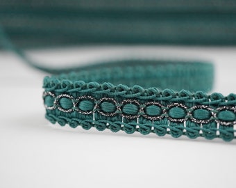 May include: Teal green trim with silver oval accents. The trim has a crocheted design.