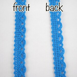 May include: A close-up of a blue lace trim, showing the front and back sides. The lace has a delicate, intricate pattern.