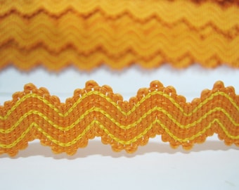 May include: Orange and yellow zig zag trim with a scalloped edge. The trim is made of a soft, woven fabric.