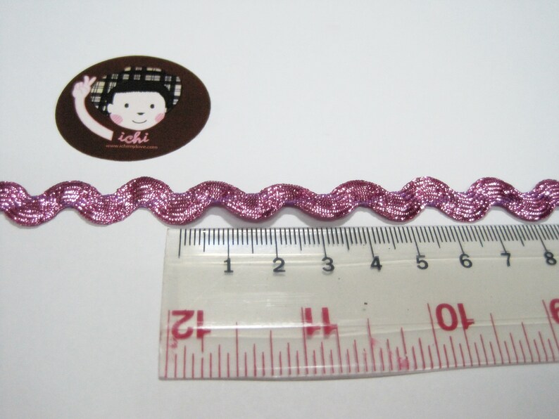 Peut inclure: Garniture ondul&eacute;e rose avec un &eacute;clat m&eacute;tallique, mesurant environ 20 cm de long.