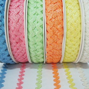 May include: Six spools of sparkly, heart-shaped trim in various pastel colours, including blue, pink, green, orange, yellow, and white.