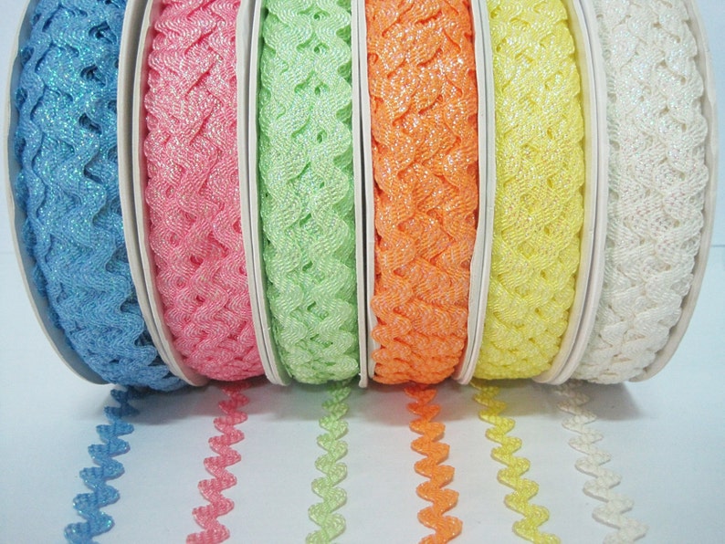 May include: Six spools of sparkly, heart-shaped trim in various pastel colours, including blue, pink, green, orange, yellow, and white.