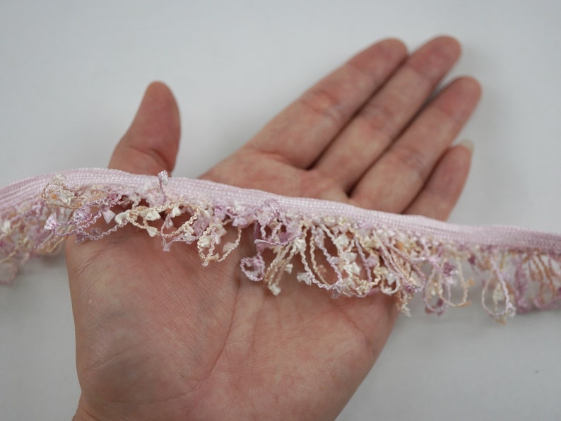 Puede incluir: Borde de flecos rosa y crema con un dise&ntilde;o delicado y texturizado. El borde es suave y fluido, perfecto para agregar un toque de elegancia a cualquier proyecto.