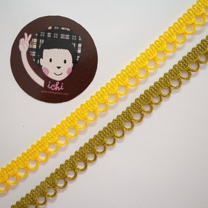 May include: Two spools of yellow and gold trim with a scalloped edge. The trim is made of a soft, woven fabric.