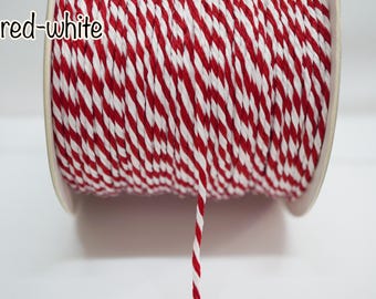 May include: A spool of red and white twisted twine featuring a candy cane striped pattern. The text red-white is printed in the upper left corner. The cord is wound tightly around a cylindrical spool, with a single strand extending downward.