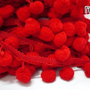 May include: Red pom-pom trim with a red ribbon base. The trim is made of soft, fluffy pom-poms.