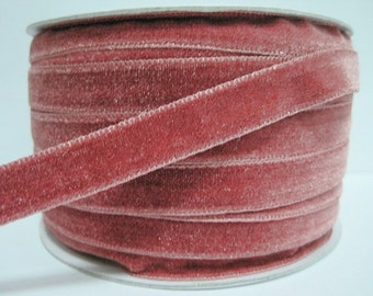 May include: A spool of dusty rose velvet ribbon. The ribbon is approximately 1/4 inch wide and is wound around a white cardboard spool.