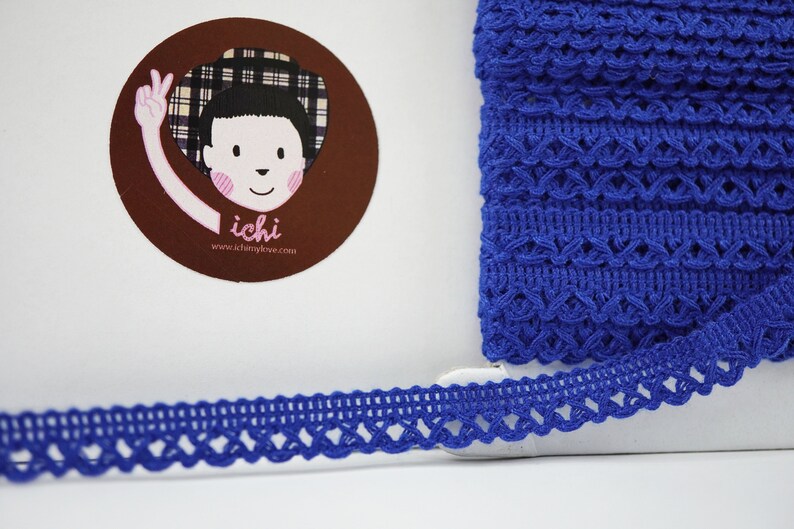May include: Royal blue crochet trim with a delicate, intricate pattern. The trim is approximately 1 inch wide and has a scalloped edge.