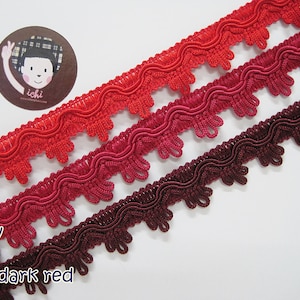 May include: Three different shades of red trim, from light red to dark red, with a wavy, scalloped edge.