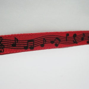 May include: Red ribbon with a black musical note design.