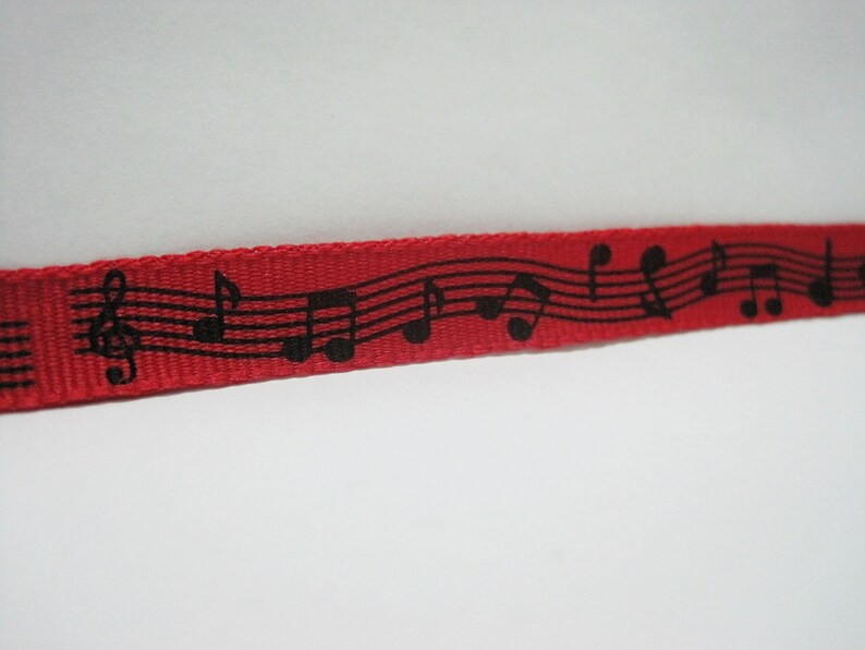 May include: Red ribbon with a black musical note design.