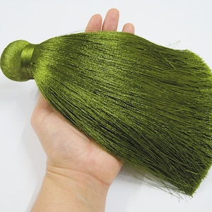 May include: A long, dark green tassel with a round, knotted top. The tassel is made of soft, silky fibres.