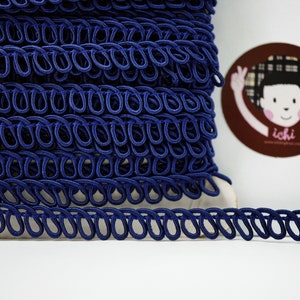 May include: A spool of dark blue elastic trim with a chain-like pattern. The trim is made of a soft, flexible material and is ideal for adding a touch of elegance to any project.