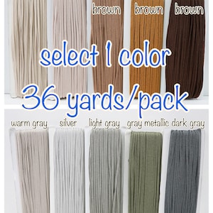 May include: A selection of 36-yard spools of elastic cord in various colors, including mocha, beige, light brown, golden brown, dark brown, warm gray, silver, light gray, gray metallic, and dark gray. Select 1 color.