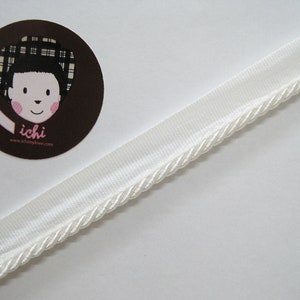 May include: White trim with a rope edge. The trim is about 1 inch wide.